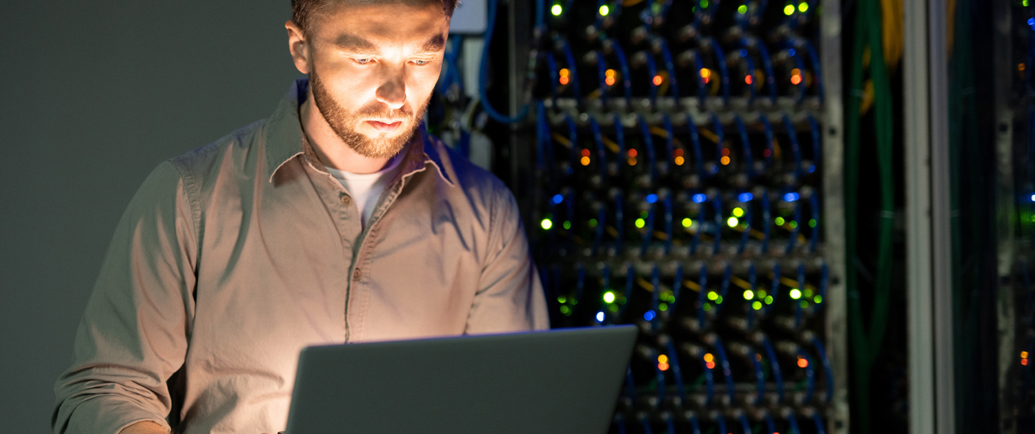 It Technician In Server Room With Rack Wires In Background