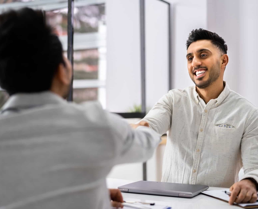 Two People Shaking Hands And Smiling