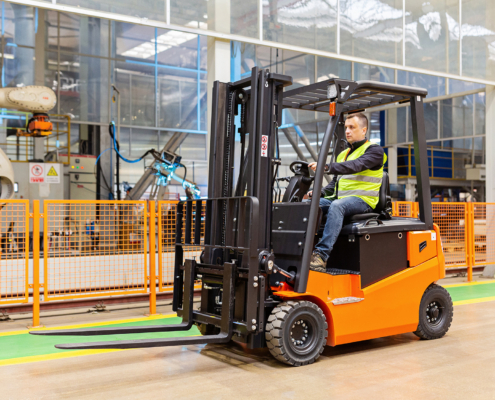 Storehouse Employee In Uniform Working On Forklift In Modern Automatic